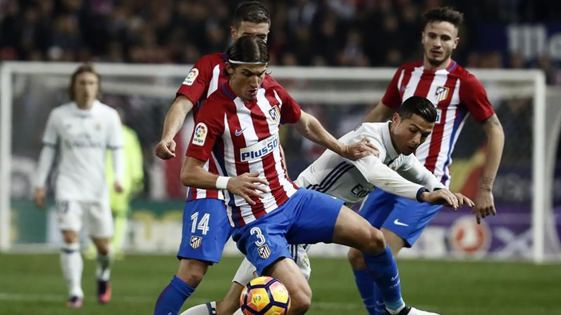 El portugués Cristiano Ronaldo (d), del Real Madrid, lucha el balón con el defensa brasielño del Atlético de Madrid Filipe Luis