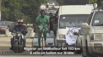 Harrison Chinedu montado en bici con el balón en la cabeza