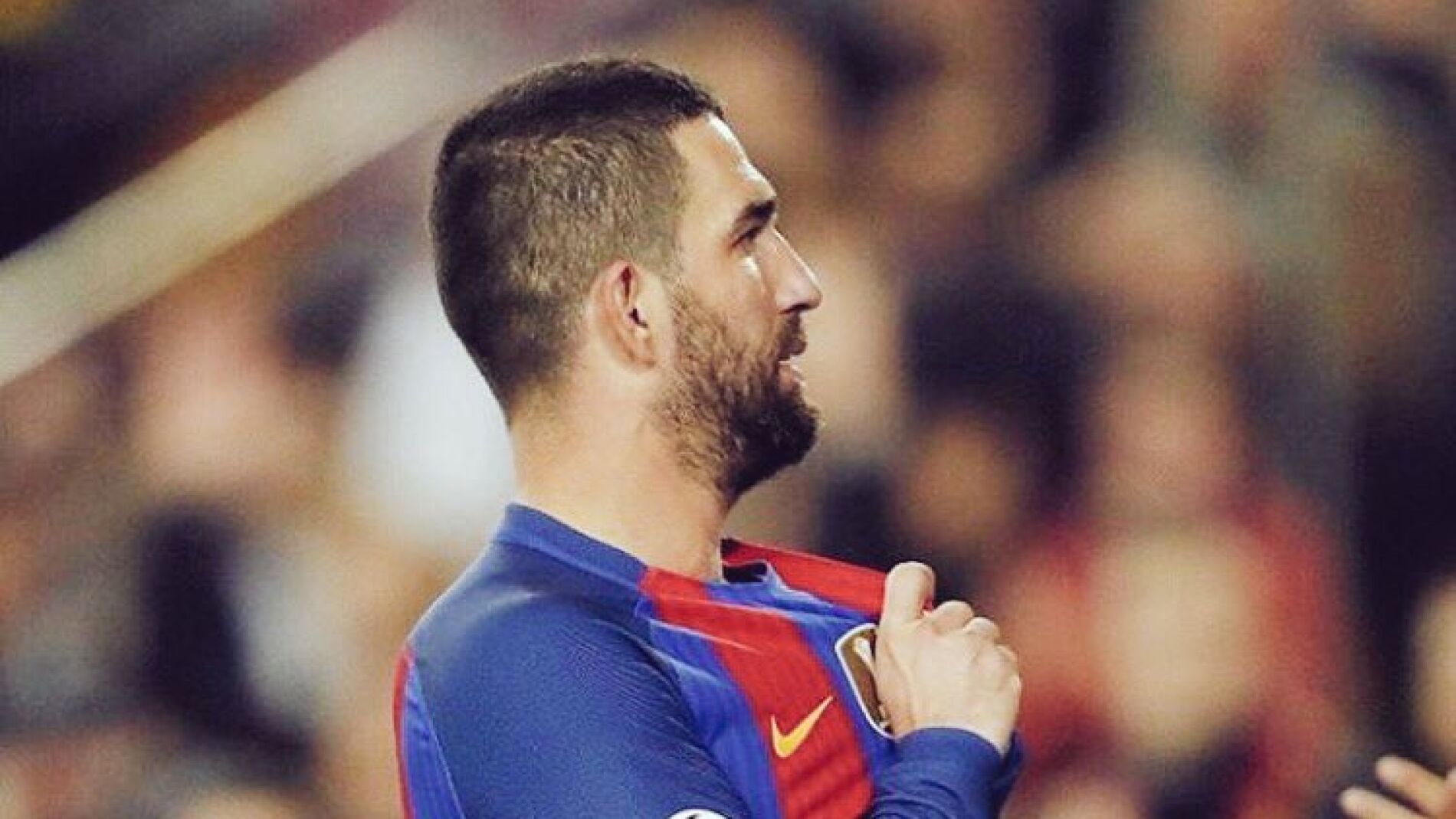 Arda Turan se se&ntilde;ala el escudo del Bar&ccedil;a en el Camp Nou