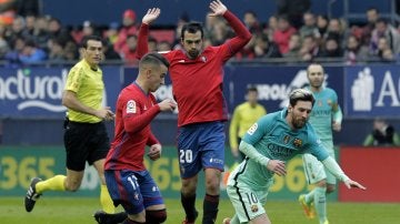 Leo Messi recibe una falta contra Osasuna