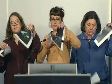 Imagen de televisión de varias diputadas de la CUP en el Parlament que rompen fotografías del Rey, durante una rueda de prensa Imagen de televisión de varias diputadas de la CUP en el Parlament que rompen fotografías del Rey, durante una rueda de prensa
