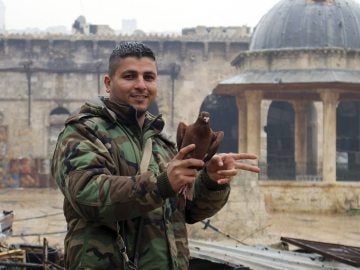 Un soldado sirio hace el símbolo de la victoria junto a la mezquita de Umayyad al este de Alepo
