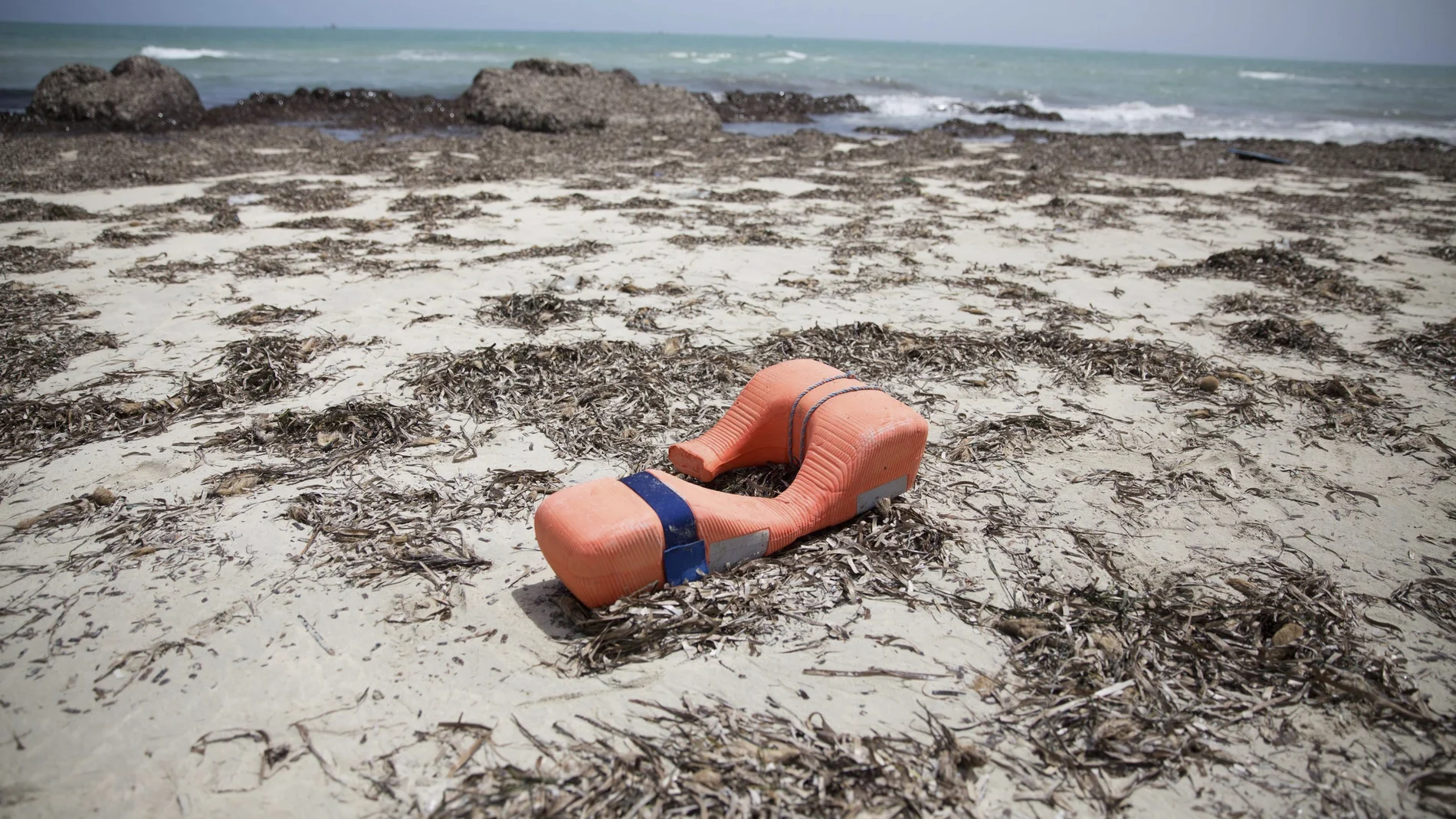 Un chaleco salvavidas permanece tirado en una playa Un chaleco salvavidas permanece tirado en una playa