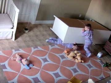 Un hermano ayuda a su gemelo a salir de debajo de un armario