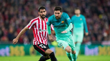 Messi conduce el balón mientras Raúl García intenta robárselo