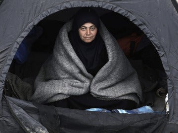 Una refugiada se resguarda del frío en una tienda