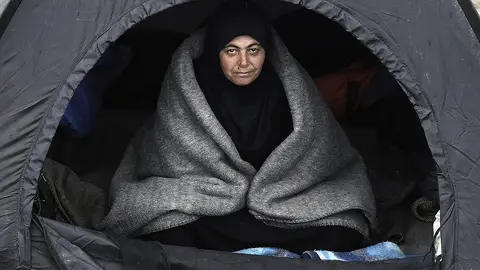 Una refugiada se resguarda del frío en una tienda Una refugiada se resguarda del frío en una tienda