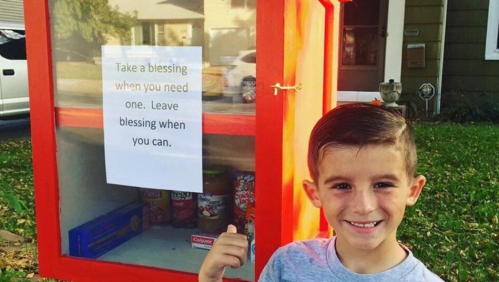 Paxton al lado de la despensa solidaria de comida