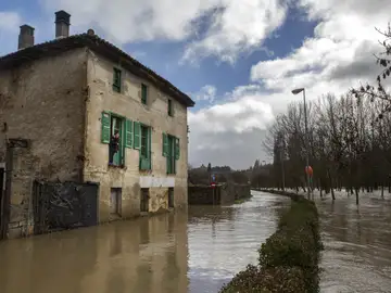 Una mujer observa desde su casa el desbordamiento del río Arga Una mujer observa desde su casa el desbordamiento del río Arga
