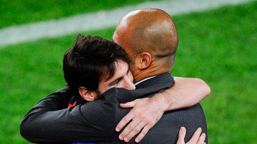 Leo Messi y Pep Guardiola se abrazan durante un partido