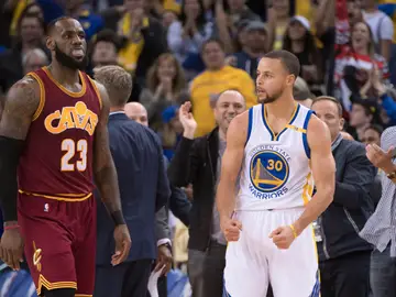 Stephen Curry celebra una canasta ante la mirada de LeBron James Stephen Curry celebra una canasta ante la mirada de LeBron James