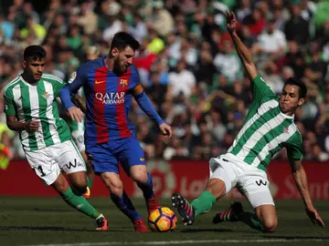 Messi, ante dos jugadores béticos Messi, ante dos jugadores béticos
