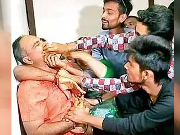 Momento en el que los activistas fuerzan al funcionario a comerse los billetes Momento en el que los activistas fuerzan al funcionario a comerse los billetes