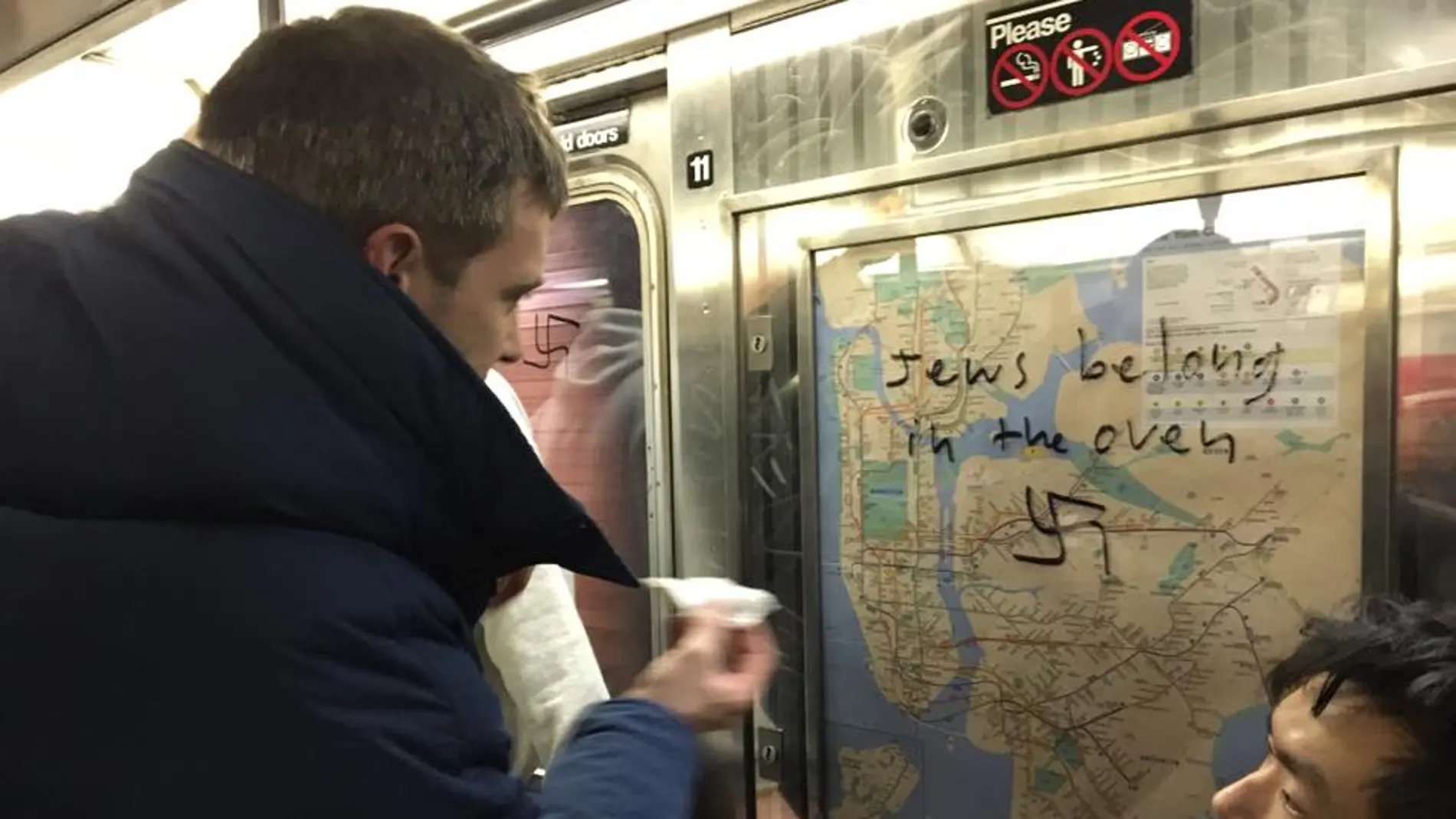 Un pasajero del metro de Nueva York elimina un mensaje de odio hacia judíos en uno de los vagones Un pasajero del metro de Nueva York elimina un mensaje de odio hacia judíos en uno de los vagones