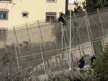 Un inmigrante en la zona alta de la valla de Melilla Un inmigrante en la zona alta de la valla de Melilla