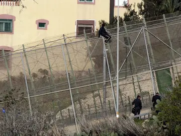 Un inmigrante en la zona alta de la valla de Melilla Un inmigrante en la zona alta de la valla de Melilla