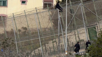 Un inmigrante en la zona alta de la valla de Melilla