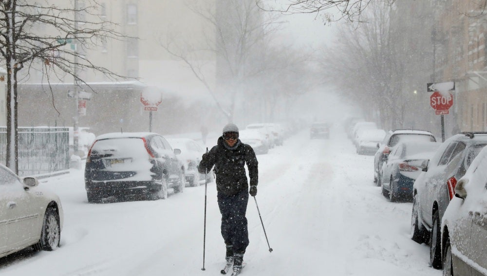 Un hombre caminando con esquís por la calle en Brooklyn
