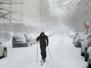 Un hombre caminando con esquís por la calle en Brooklyn