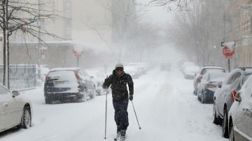 Un hombre caminando con esquís por la calle en Brooklyn