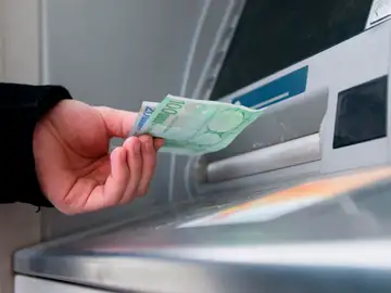 Un hombre saca dinero del cajero automático Un hombre saca dinero del cajero automático