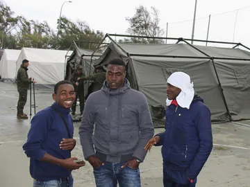 Un grupo de inmigrantes al lado de una tienda de campaña Un grupo de inmigrantes al lado de una tienda de campaña