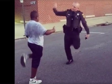 Un agente de policía baila con un adolescente