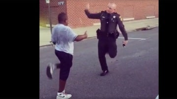Un agente de policía baila con un adolescente