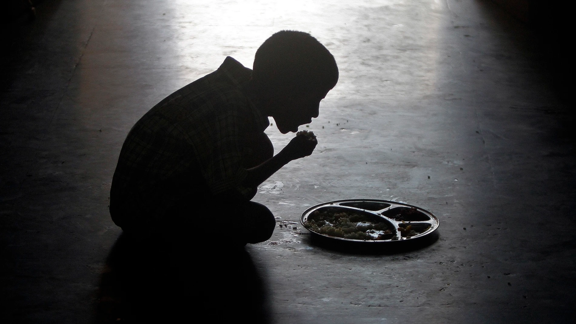 Un niño comiendo en un orfanato de la India Un niño comiendo en un orfanato de la India