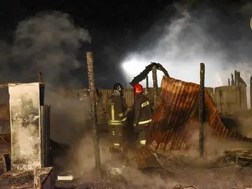 Bomberos tratan de extinguir el fuego en un campamento de inmigrantes en la localidad de Rignano Garganico, en Italia Bomberos tratan de extinguir el fuego en un campamento de inmigrantes en la localidad de Rignano Garganico, en Italia