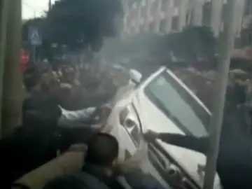 Momento en el que los transeúntes le dan la vuelta al coche Momento en el que los transeúntes le dan la vuelta al coche
