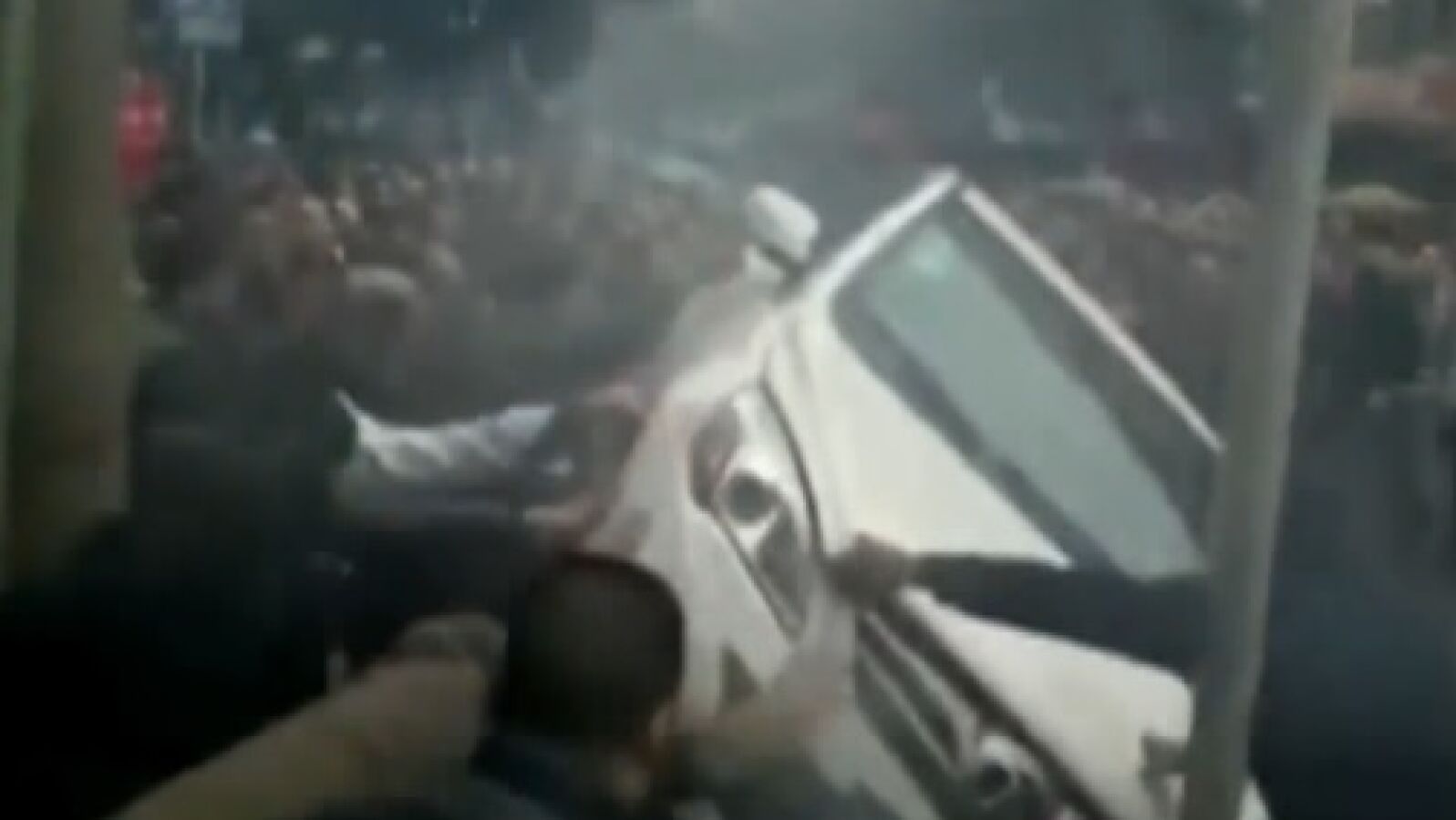 Decenas de transeúntes unen sus fuerzas para darle la vuelta a un coche y liberar a una mujer que había quedado atrapada