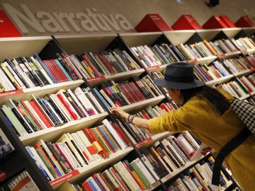 Una mujer mira libros en los estanterías de una librería