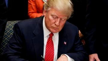 Trump firmando una orden ejecutiva
