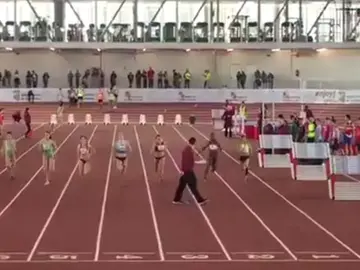 Un juez, paseándose por la pista de atletismo durante una prueba Un juez, paseándose por la pista de atletismo durante una prueba