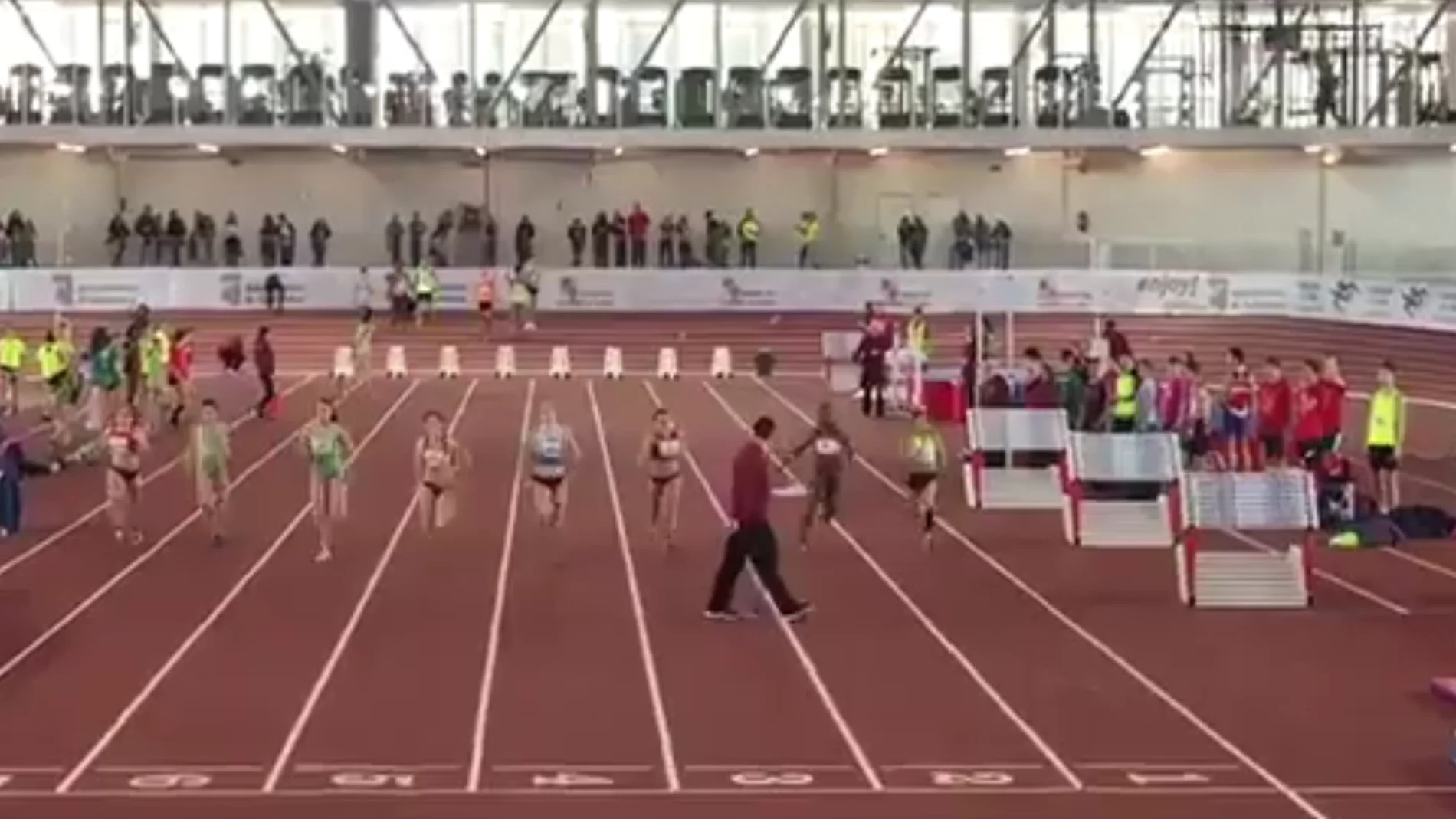 Un juez, paseándose por la pista de atletismo durante una prueba Un juez, paseándose por la pista de atletismo durante una prueba