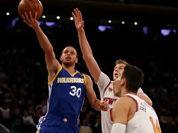 Curry hace una bandeja ante la defensa de Porzingis y Willy Hernangómez Curry hace una bandeja ante la defensa de Porzingis y Willy Hernangómez