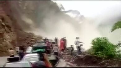 Desprendimiento de rocas y tierra sobre una carretera transitada por el agua acumulada