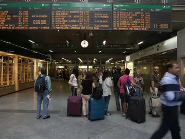 Viajeros miran los horarios en la estación madrileña de Atocha Viajeros miran los horarios en la estación madrileña de Atocha