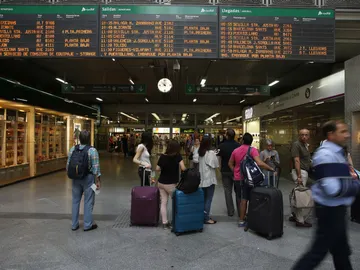 Viajeros miran los horarios en la estación madrileña de Atocha Viajeros miran los horarios en la estación madrileña de Atocha
