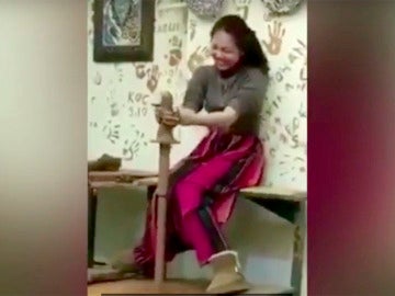 La joven no puede contener la risa al ver la figura que ha hecho con la arcilla La joven no puede contener la risa al ver la figura que ha hecho con la arcilla