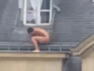 Un hombre desnudo se esconde en el alféizar de una ventana Un hombre desnudo se esconde en el alféizar de una ventana