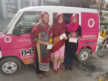 Tres mujeres pakistaníes posan junto a uno de los taxis rosas que circulan para proteger a las mujeres del acoso Tres mujeres pakistaníes posan junto a uno de los taxis rosas que circulan para proteger a las mujeres del acoso