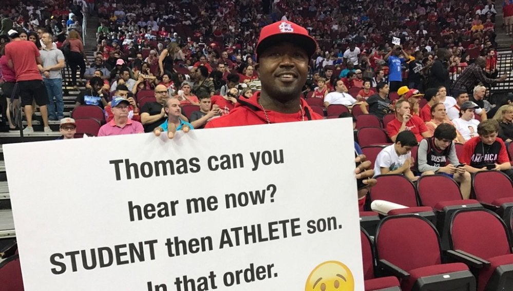 El padre, con una de sus pancartas en la cancha de los Rockets