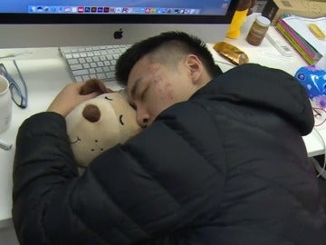 Un asiático durmiendo en el trabajo para no perder tiempo