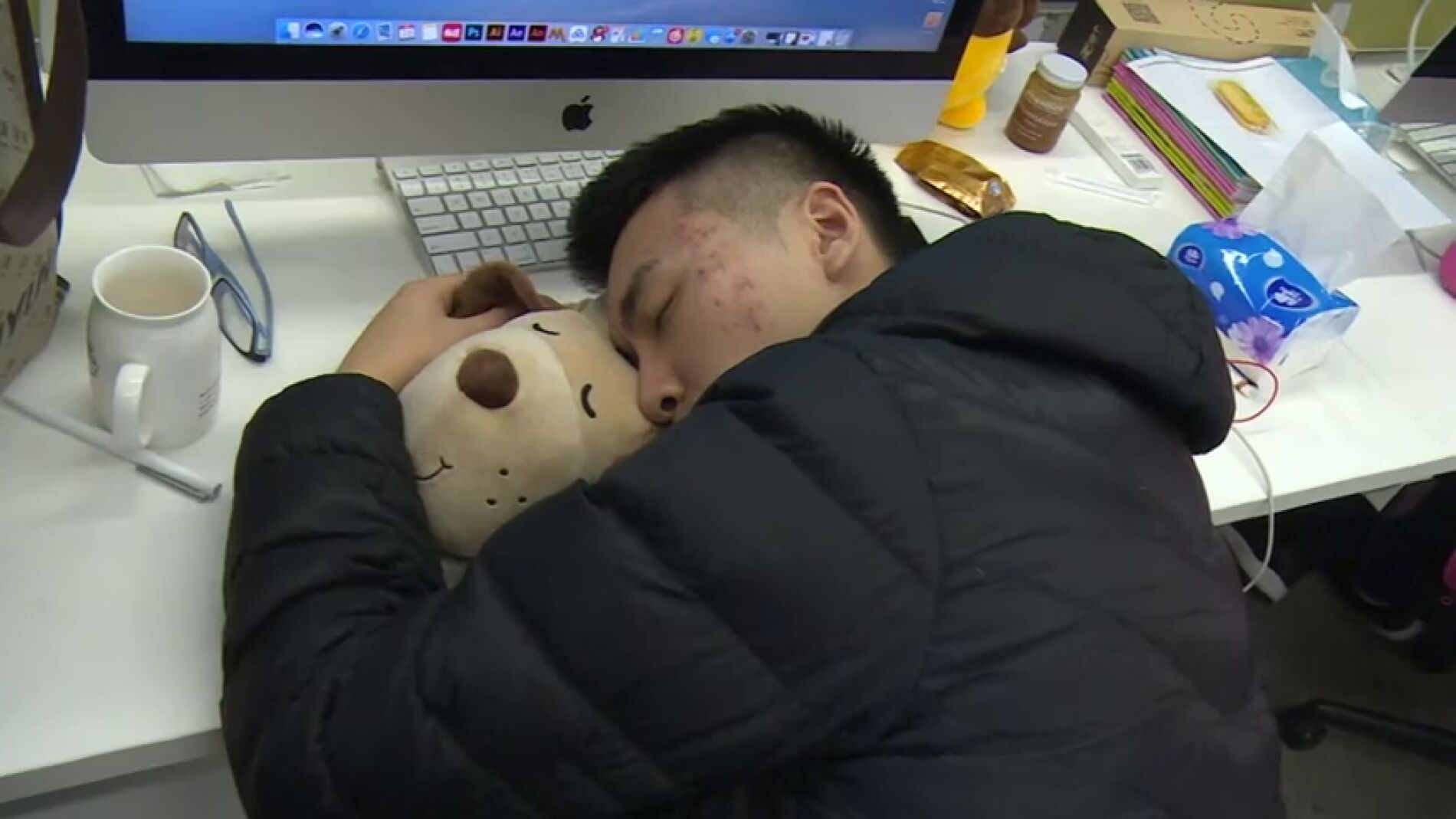 Un asi&aacute;tico durmiendo en el trabajo para no perder tiempo