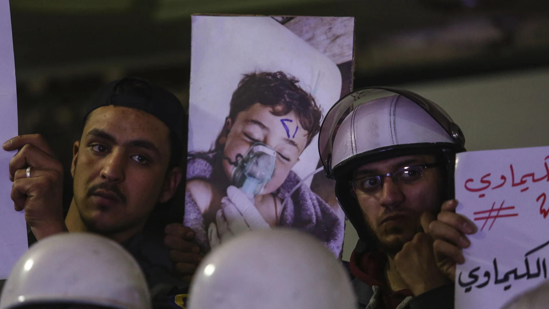 Voluntarios y personal de servicios de primeros auxilios con pancartas e imágenes de los fallecidos en el ataque químico en Siria Voluntarios y personal de servicios de primeros auxilios con pancartas e imágenes de los fallecidos en el ataque químico en Siria