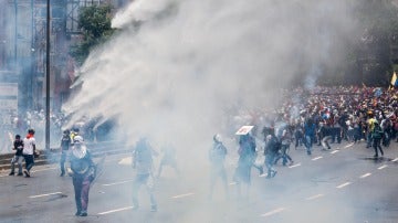 Un grupo de manifestantes se enfrenta con la policía durante una protesta