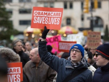 Un manifestante sostiene un cartel con el mensaje 'Obamacare salva vidas'