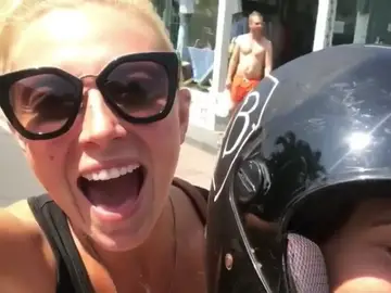 La joven montada en una moto sin casco La joven montada en una moto sin casco